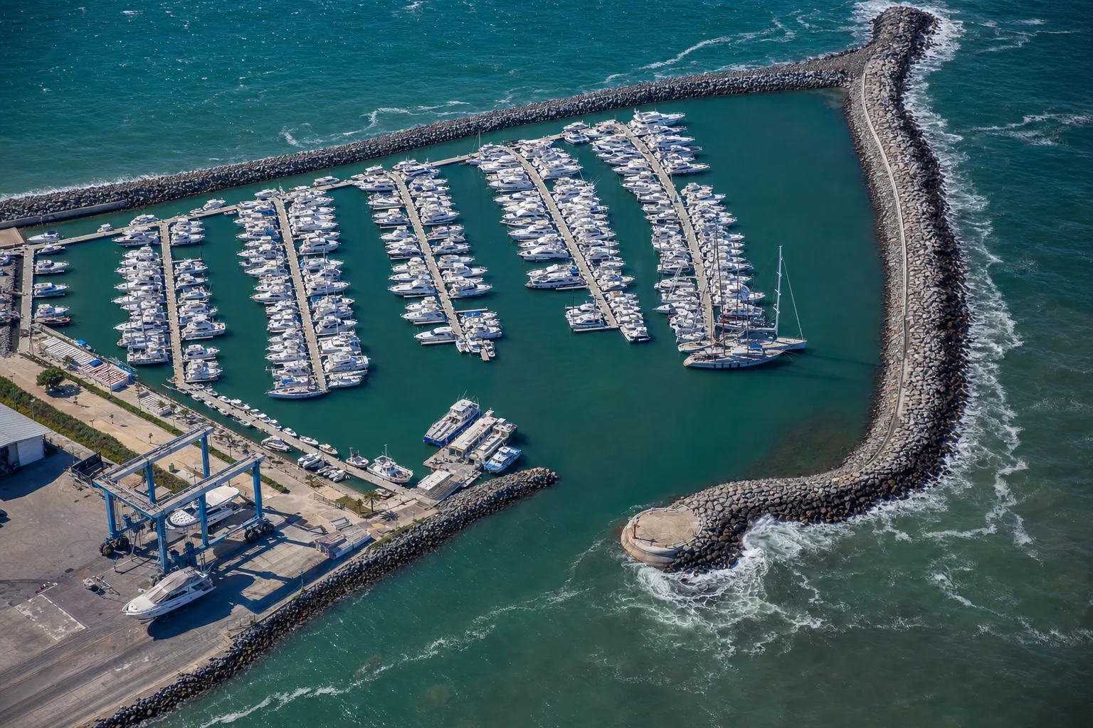 A marina seen from above with yachts moored in neat rows